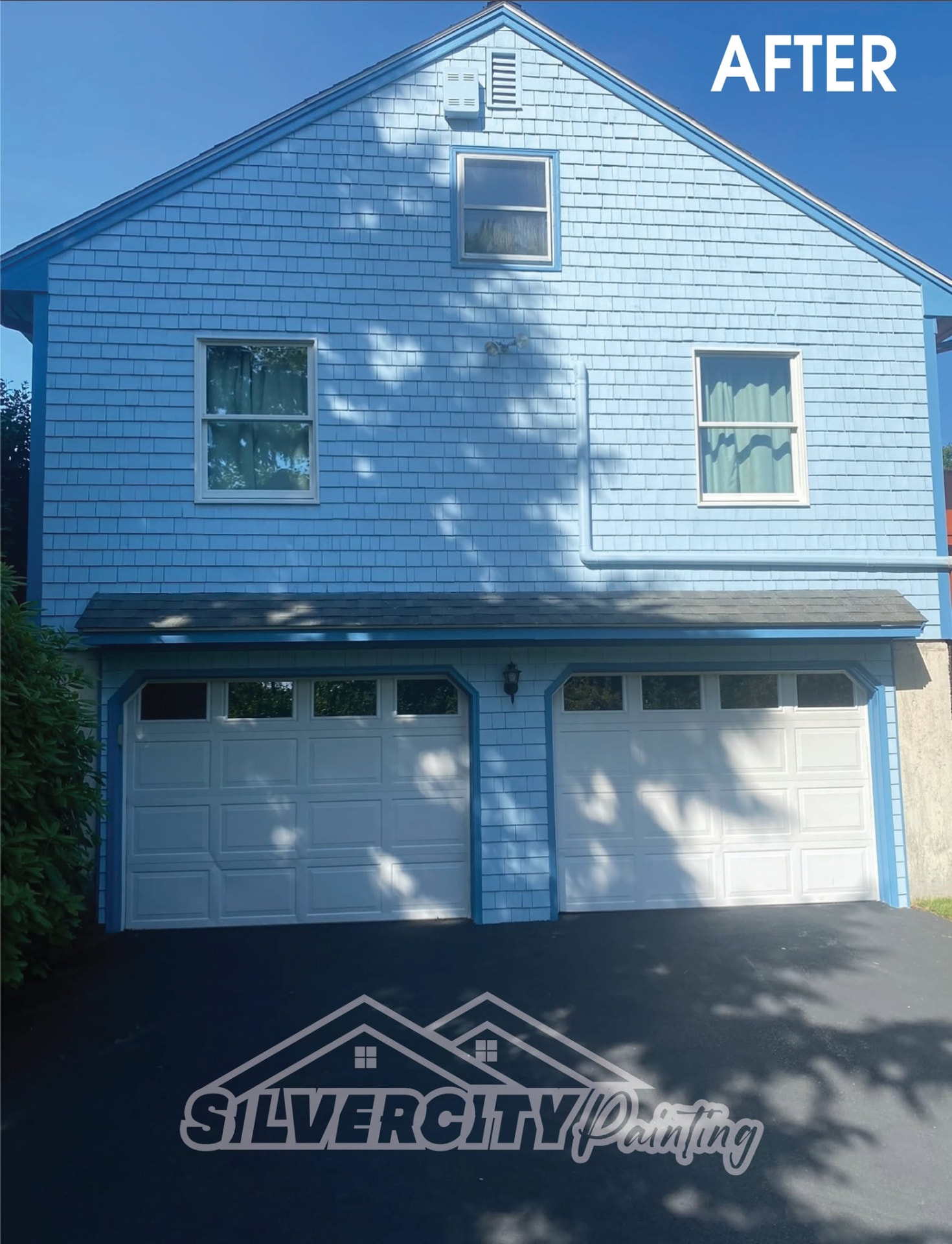 Freshly painted blue cedar shingle home with white garage doors by Silver City Painting in Taunton, Massachusetts